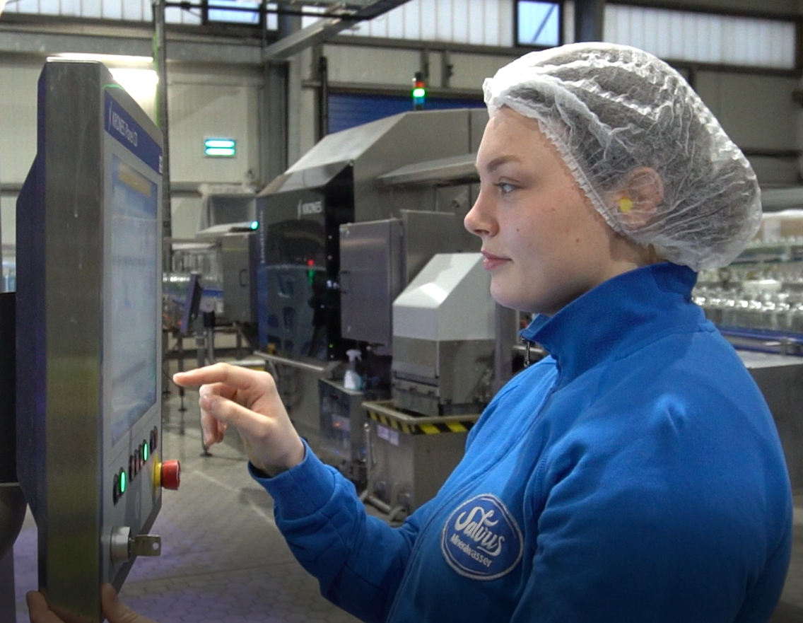 Azubine Jessica Wallochny, wie sie innerhalb der Produktion zur Fachkraft für Lebensmitteltechnik ausgebildet wird.