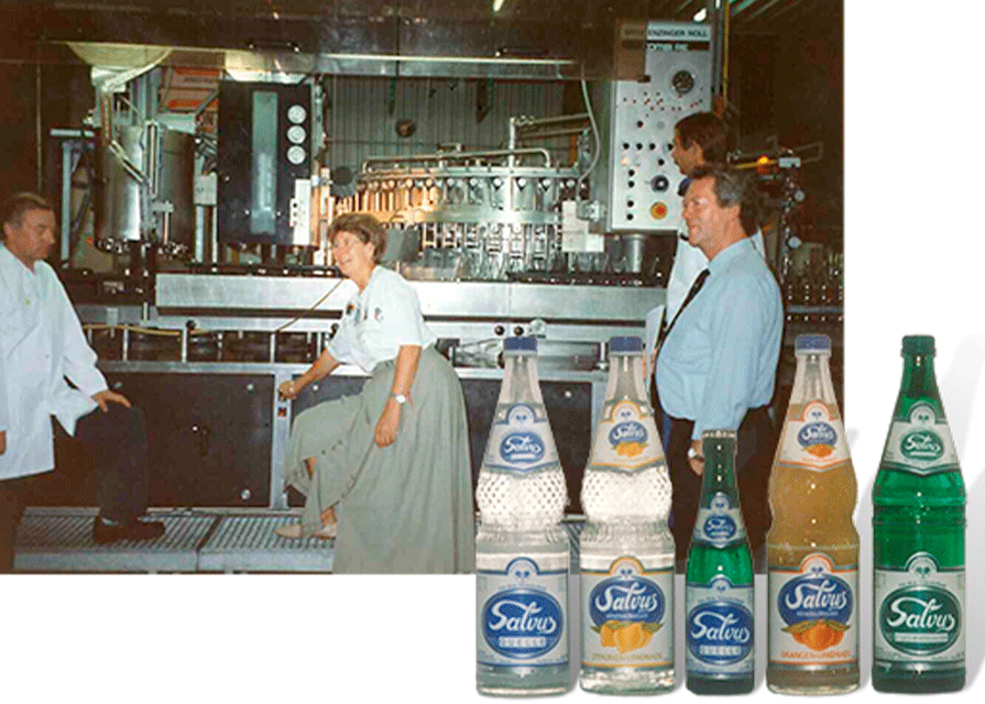 Darstellung von drei Personen unter anderem Hermann Schürkötter, die gezeigt werden, als die ersten Salvus-Produkte 1994 vom Band laufen.